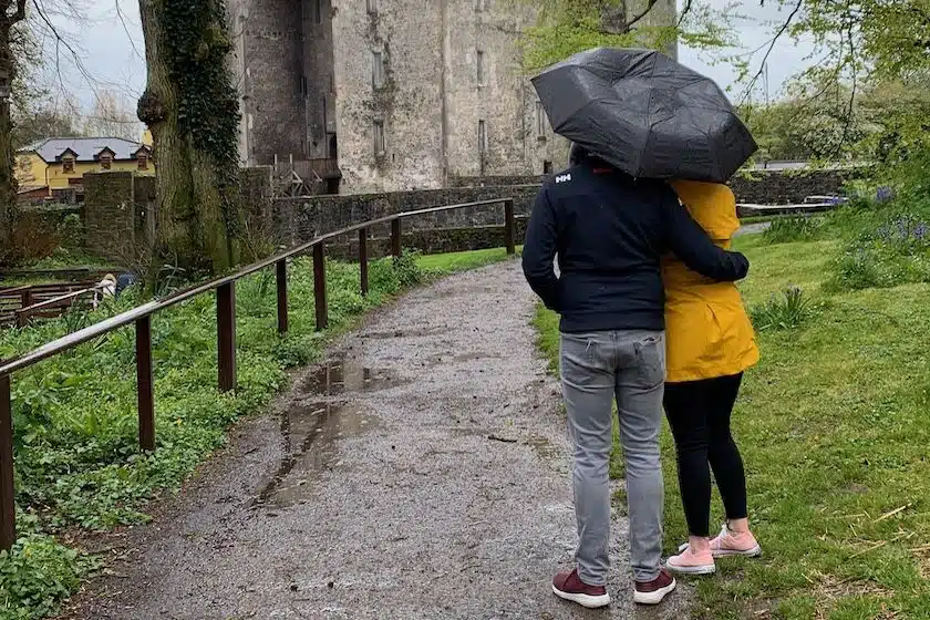 Couple under umbrella looking at a castle
