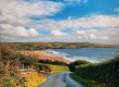 A small road leads down to a beach on a sunny day