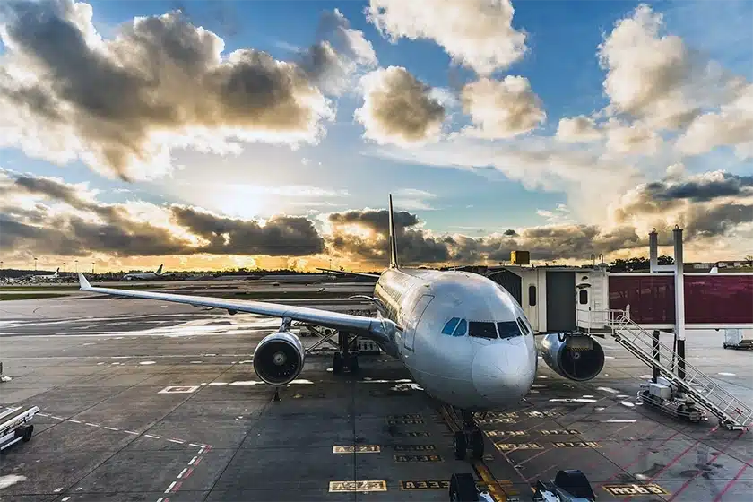 Airplane on the runway with passengers border through a stair tunnel.